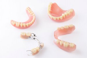 Full and partial dentures resting against neutral background