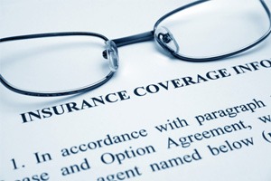 Close-up of insurance coverage info document and eyeglasses