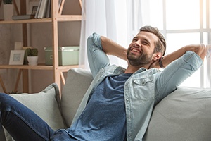 Man smiling while resting on sofa at home