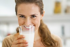 Happy, smiling woman drinking milk, a tooth-friendly beverage
