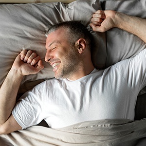 Man waking up refreshed after a good night of sleep