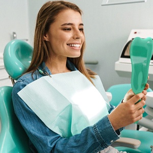 Happy patient admiring the results of her dental bonding in Belmont