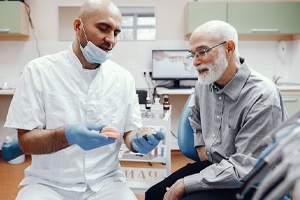 Dentist and senior patient discussing need for dentures