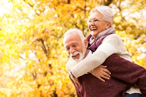 Happy, smiling senior couple enjoying benefits of dentures