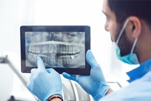 Dentist holding tablet, explaining dental X-ray