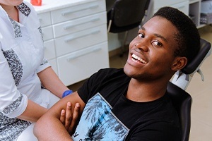 Man in dental chair smiling after tooth extraction