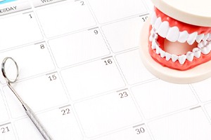 Dental mirror and tooth model on top of calendar