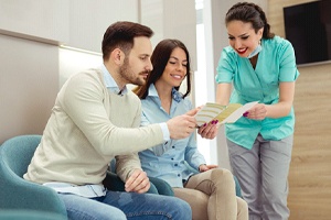 Young couple learning about their options for paying for dental implants