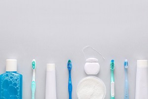 Tools for oral hygiene lined up against neutral background
