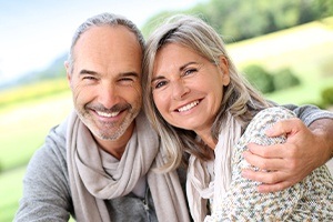 Man and woman smiling after dental implant tooth replacement