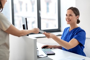 Patient handing over payment for metal free restoration