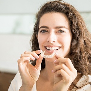 Woman placing Invisalign® clear braces tray