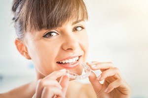 Woman placing Invisalign® clear braces tray