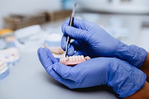 Dental lab technician carefully working on partial denture