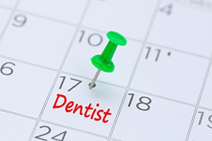 Dentist appointment marked on calendar by green thumbtack