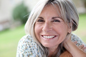 Woman smiling after full mouth reconstruction and rehabilitation