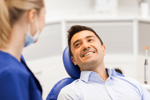 Smiling dental patient learning about the cost of root canal treatment