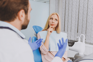 Dental patient thinking, considering her treatment options