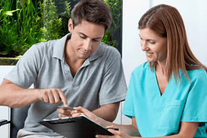 Patient and dental team member looking at credit card
