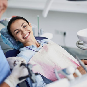 Happy patient reclined in dental treatment chair