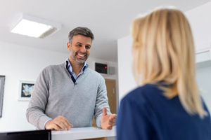 Patient talking to dental team member at front desk
