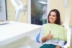 Happy woman at appointment to maximize dental insurance benefits