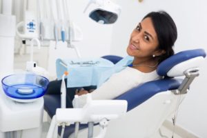 Smiling woman reclining in dental treatment chair
