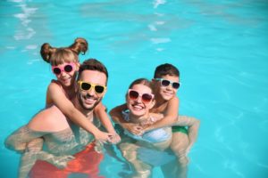 Smiling, happy family in swimming pool