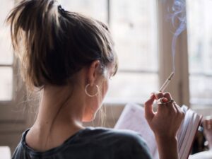 Woman smoking while reading a book