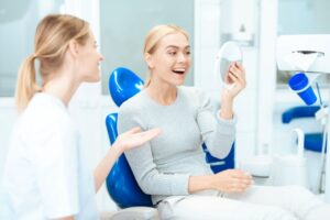 Happy dental patient admiring the results of her cosmetic procedure