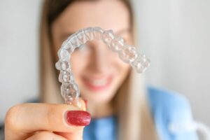 Close-up of Invisalign aligner in woman’s hand 