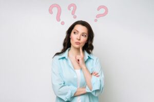 Thinking woman with question marks above her head 